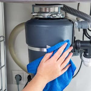 A woman cleaning a garbage disposal