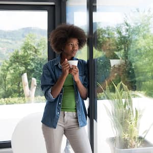 Woman drinking coffee and looking out the window