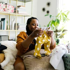 A woman folding the laundry in the living room