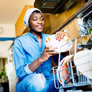 A woman loading the dishwasher with dishes 