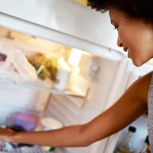 A woman looking inside a fridge