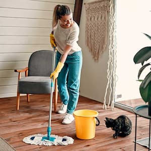 woman smiling to her cat is mopping the floor