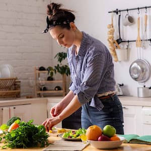 A woman preparing a meal on a wooden countertop