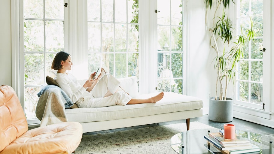 A woman relaxing on sofa in a bright living room