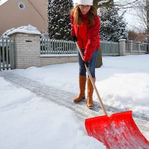 A woman shovelling snow