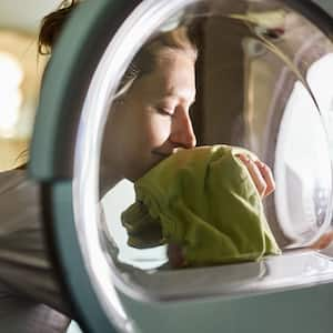 A woman smelling freshly washed clothes