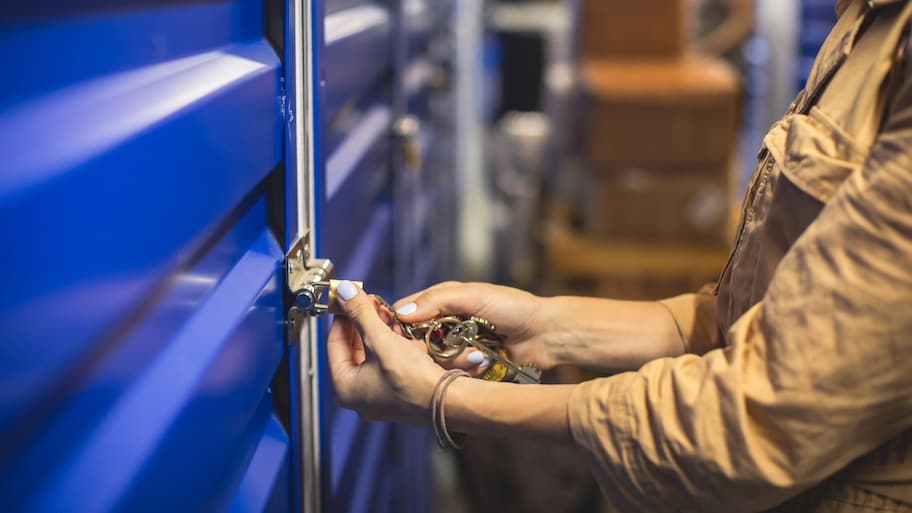 Close-up of a woman unlocking a self-storage unit