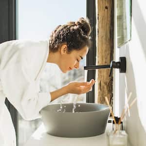 A woman washing her face in the bathroom sink