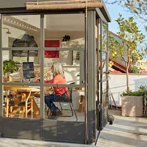 A woman working from her house sunroom 