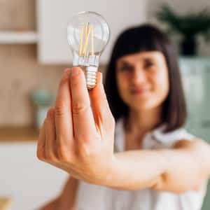 Woman holding light bulb at home