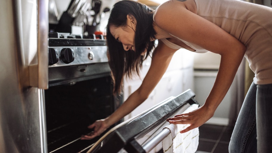 Woman taking out the cake from the oven