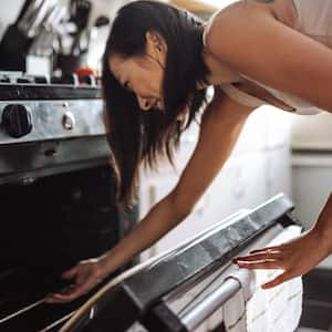 Woman taking out the cake from the oven