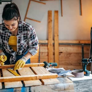 Woman works at workbench in garage