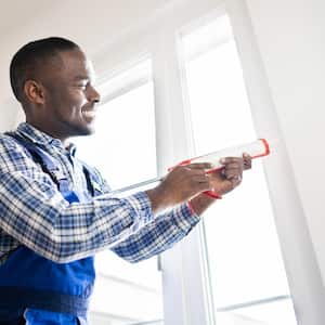 A worker applying silicone seal