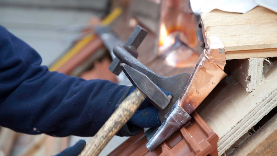 A worker installing copper gutters