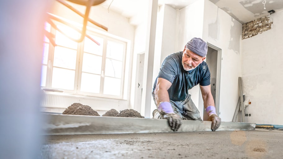 A worker preparing the subfloor by levelling it