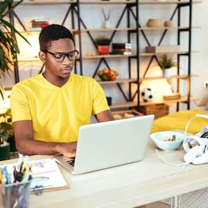 Young man using laptop to do his homework