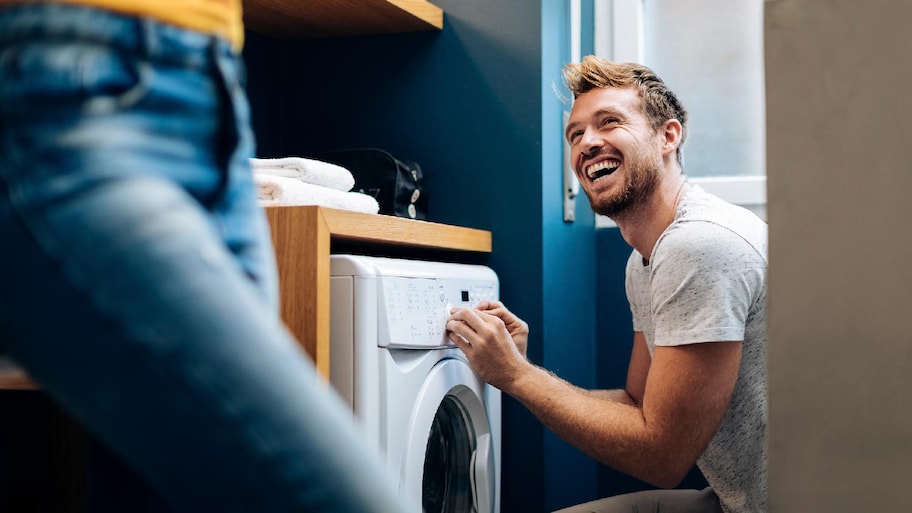 A young man loading a washing machine