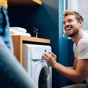 A young man loading a washing machine