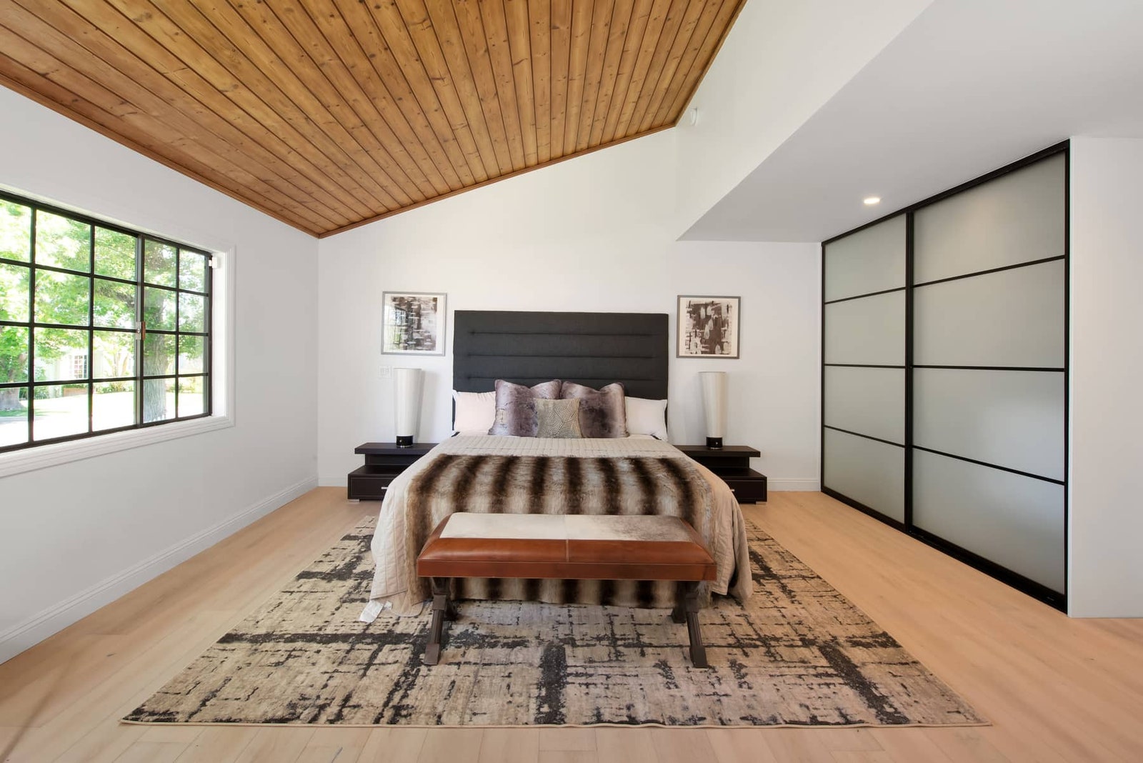 a bedroom with a wooden ceiling