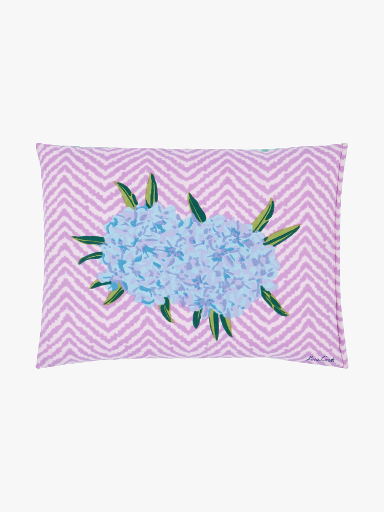 Pillow with purple zigzag pattern and oleander flower printed on it.