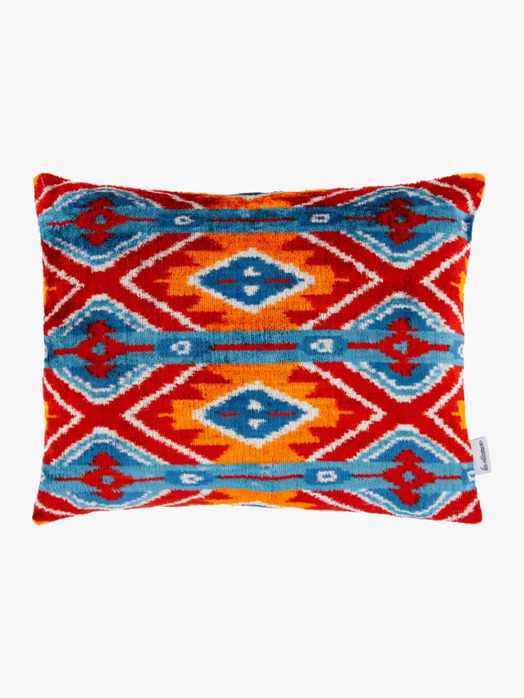 Rectangular pillow with a red blue orange and white ikat pattern.