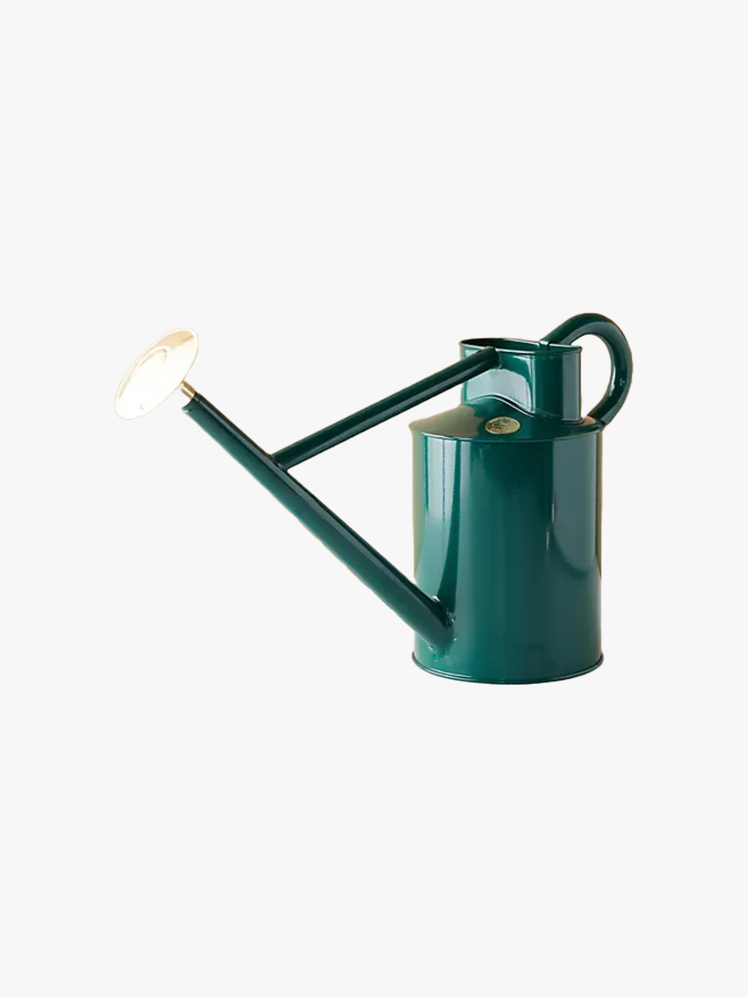 Green tin watering can with a gold cap.