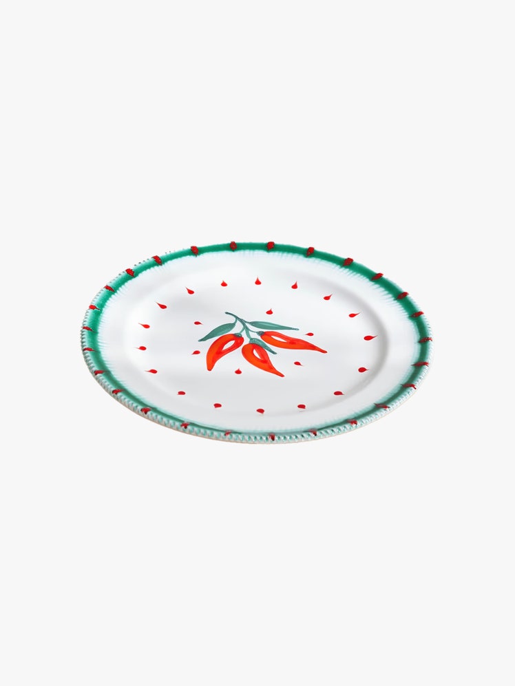 Porcelain plate with chili motifs painted at the center and rim.