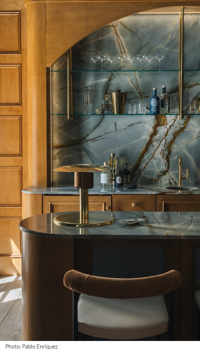 Bar designed by Night Palm with blue marble countertops and backsplash open shelving and gold hardware.