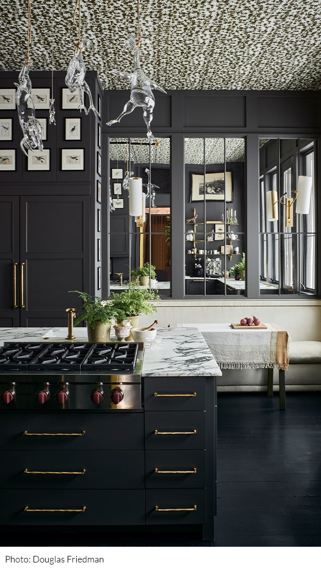 Kitchen designed by Fern Santini with black paneled walls and dark wood floors a white patterned ceiling marble...