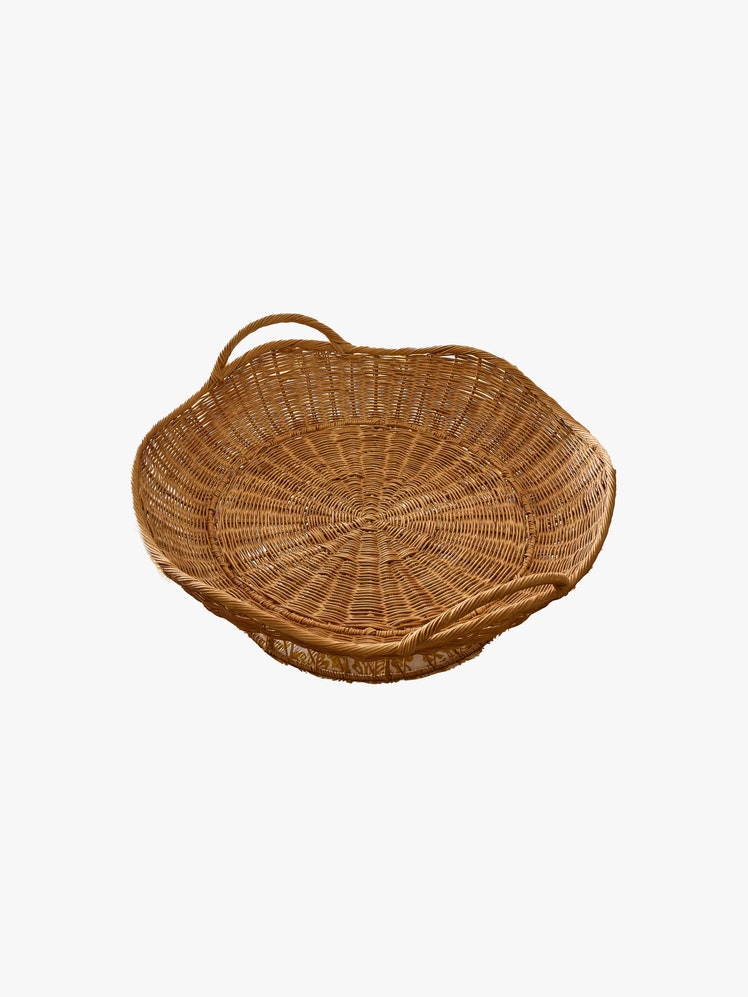 Circular wicker basket with curved edge and handles.