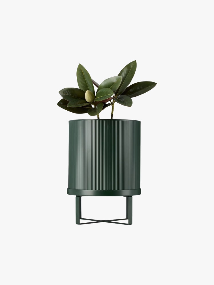 Ribbed powder coated galvanized steel pot in dark green with a plant inside it.