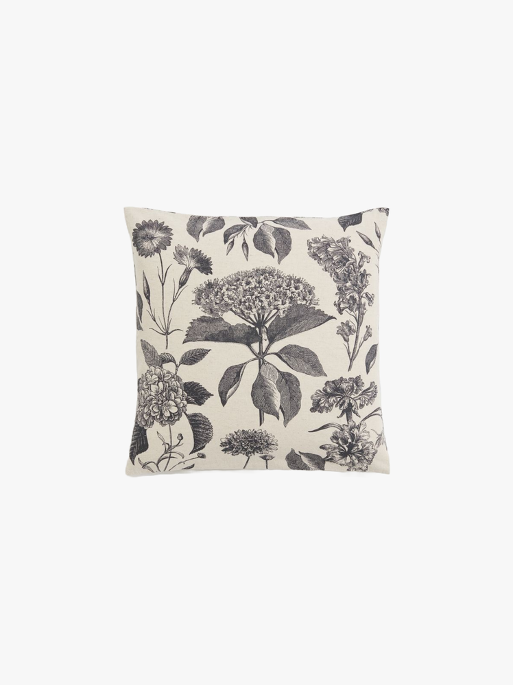 Square pillow cover with black and white scientific illustrations of assorted flowers.