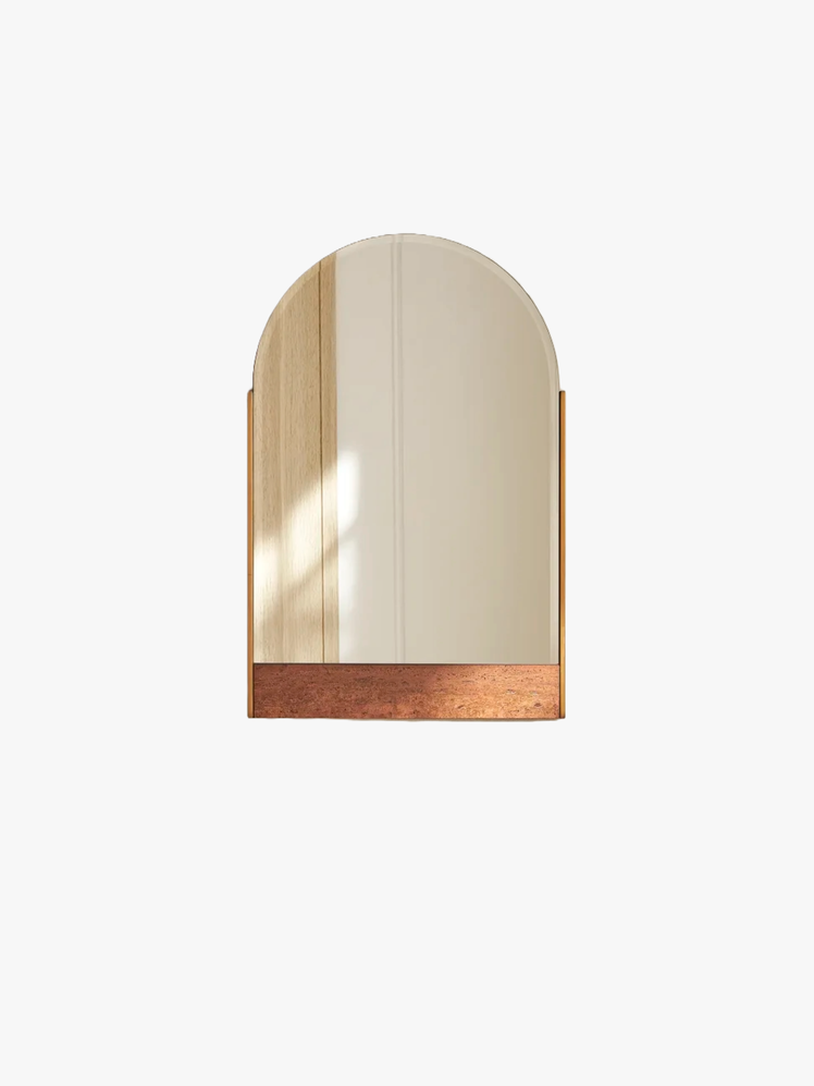 Mounted mirror with an arched form thats juxtaposed against a red travertine base.