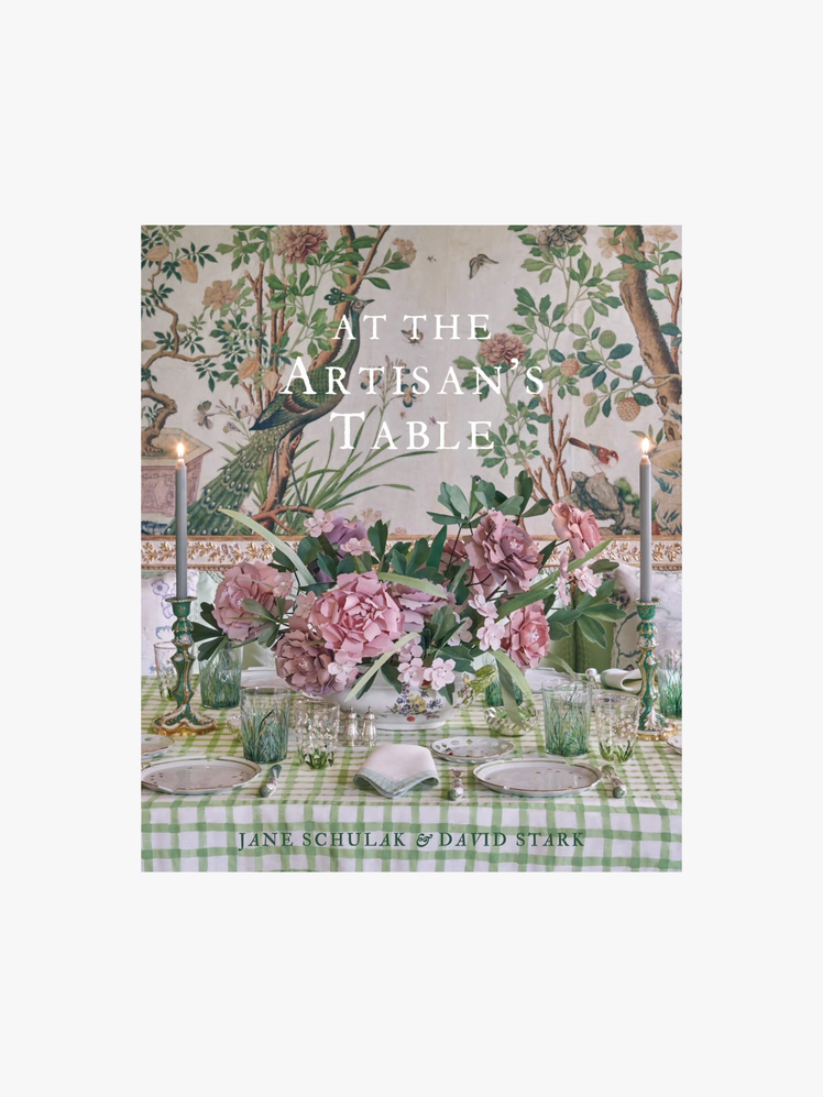 Book cover of a table setting including a green plaid tablecloth and a lush floral centerpiece as well as lit candles.