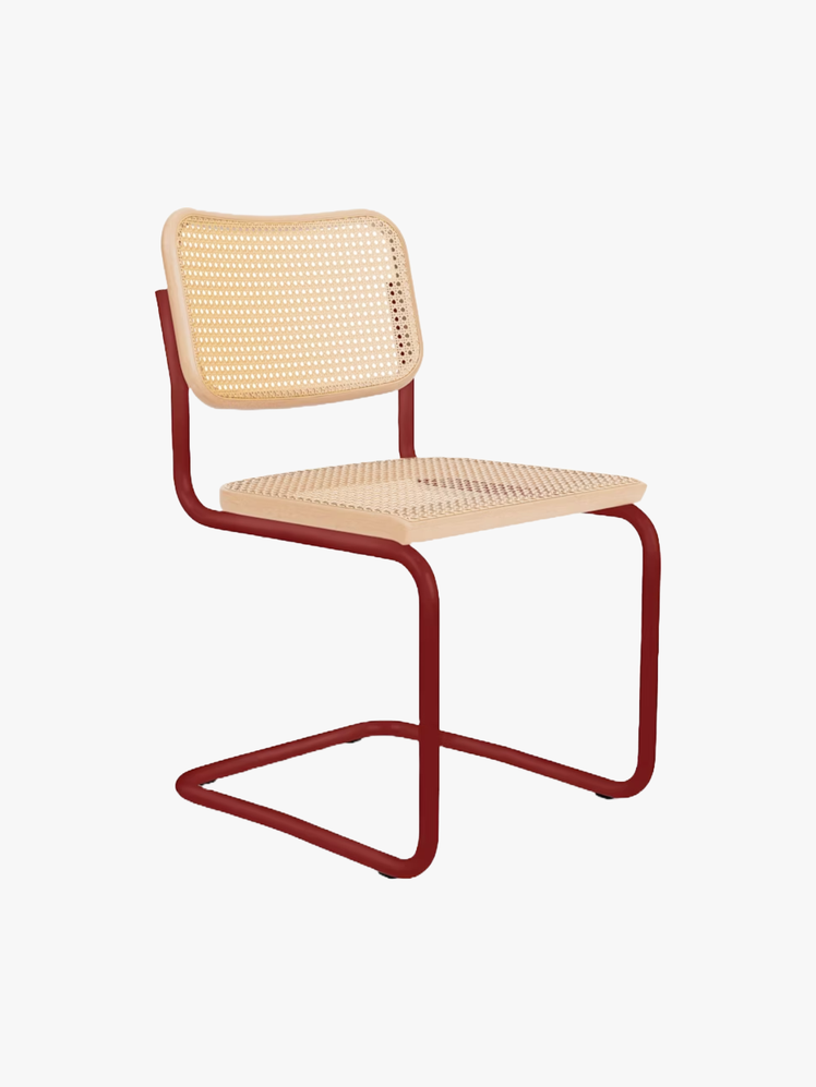 Cantilever chair with red tubular metal frame and a cane seat and seat back.