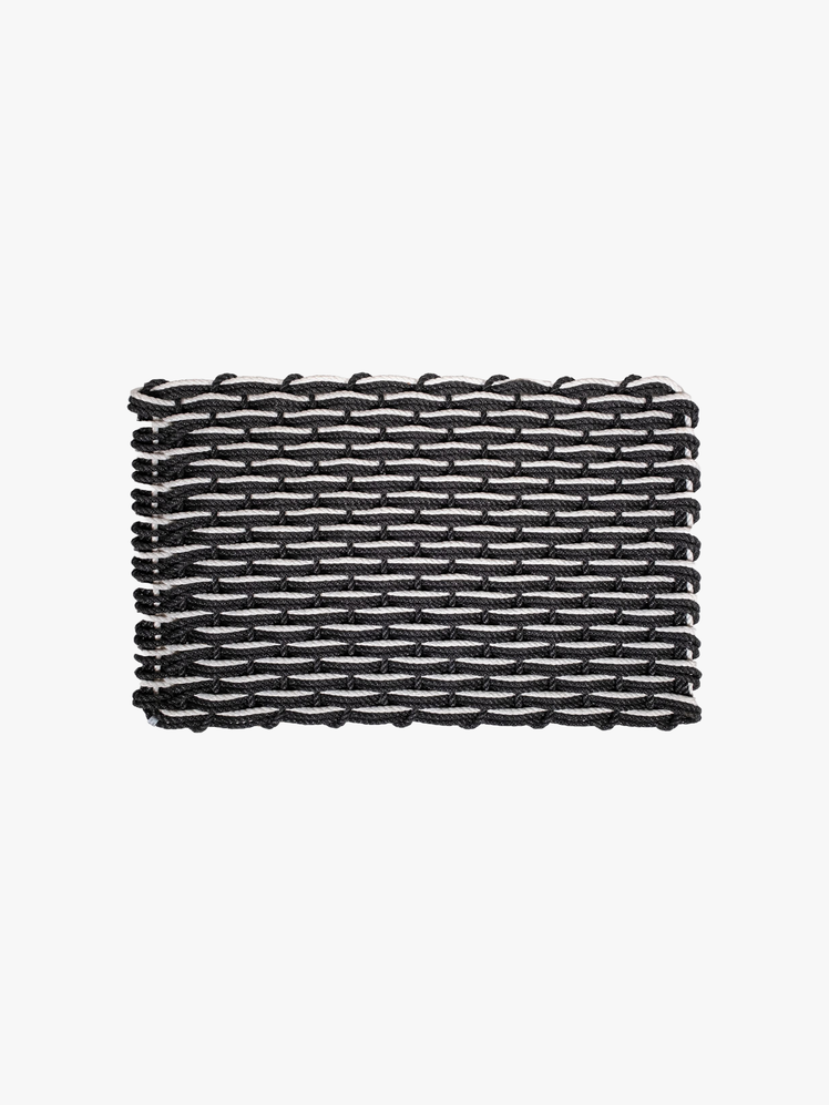 Black and white woven doormat made from rope.