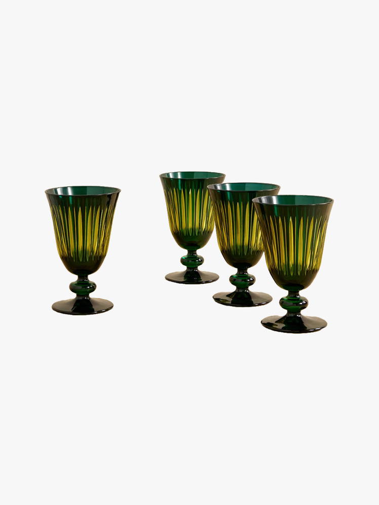 Four dark green glass wine glasses with fluted sides.