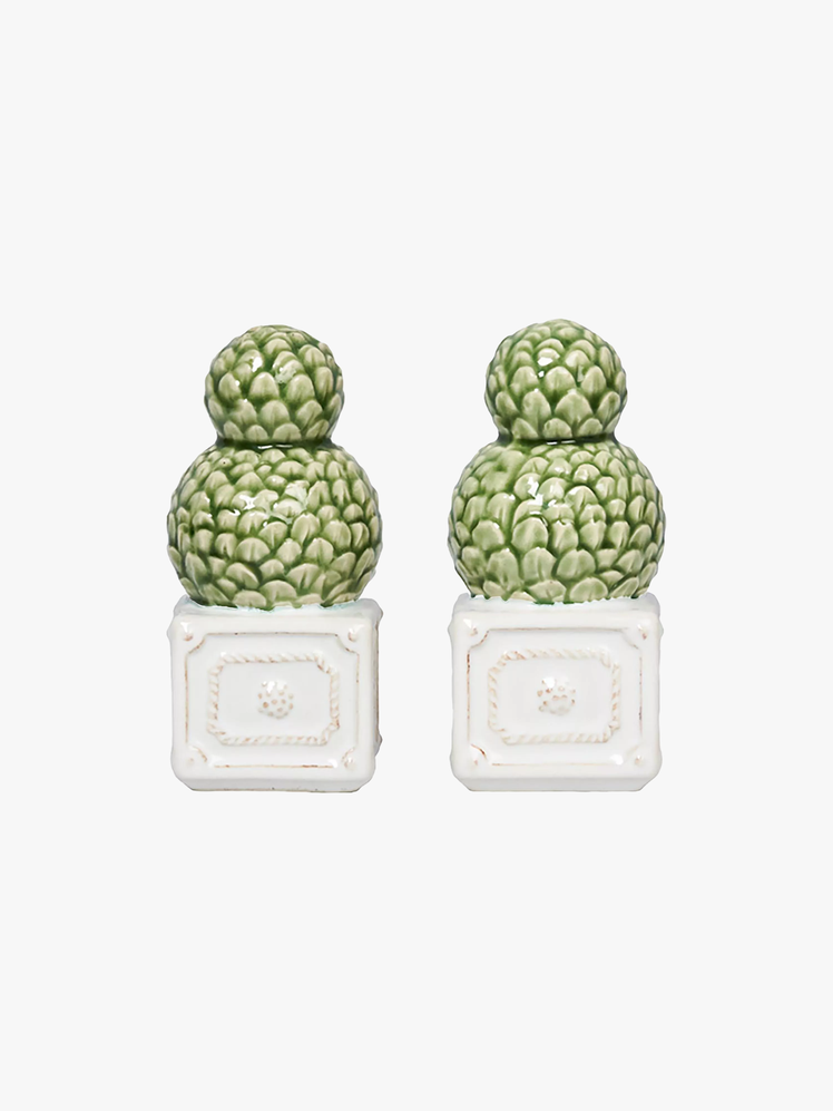 Salt and pepper shakers shaped like spherical topiary bushes inside white square planters.