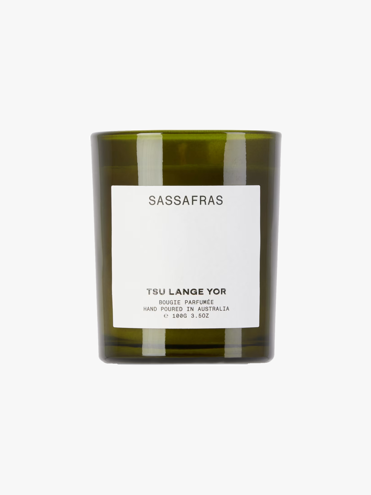 Sassafras scented candle in a dark green glass container.