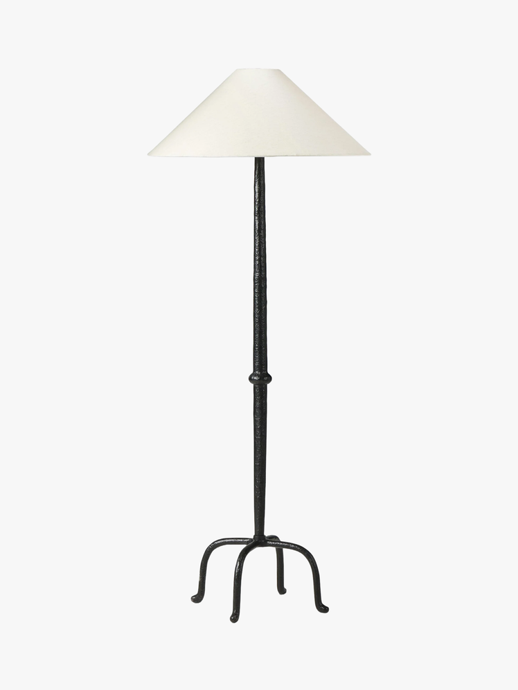 Floor lamp with four legs at bottom and tapered shade at top.