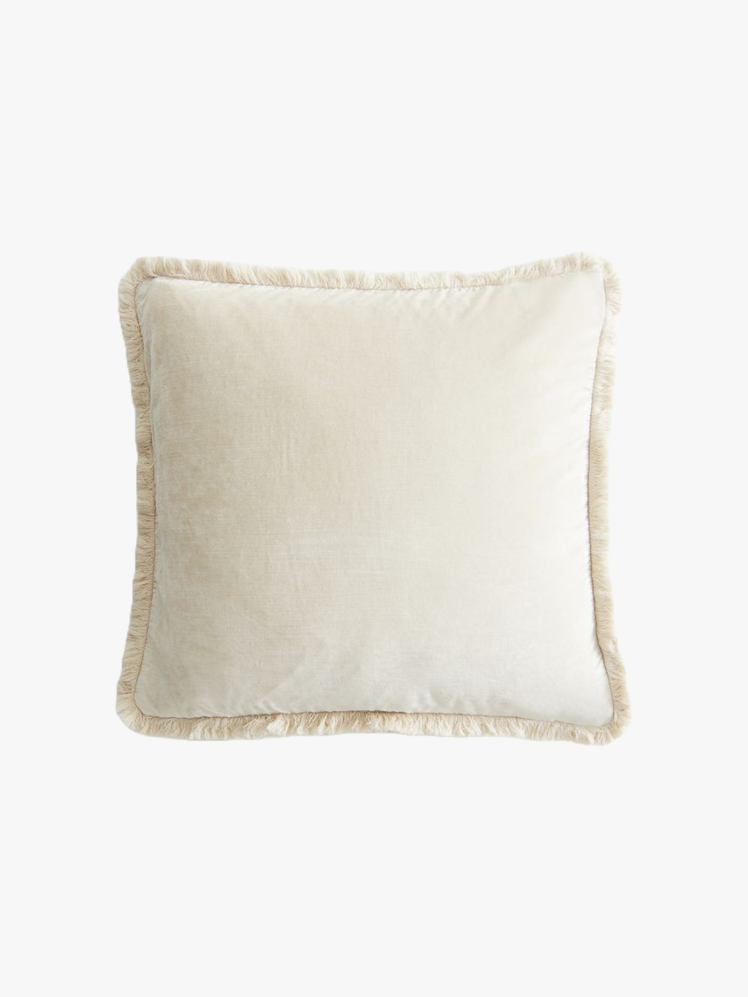 Cushion cover in white velvet with fringe at edges.