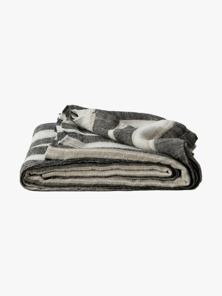 Folded up gray and white striped linen blanket.