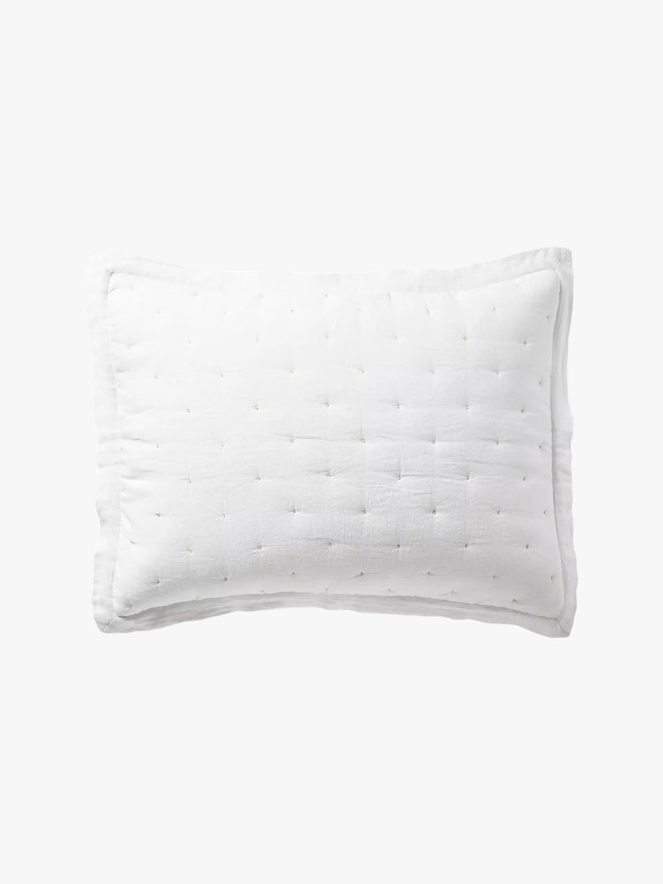 Rectangular pillow with a white linen sham that has tufted detailing on it.