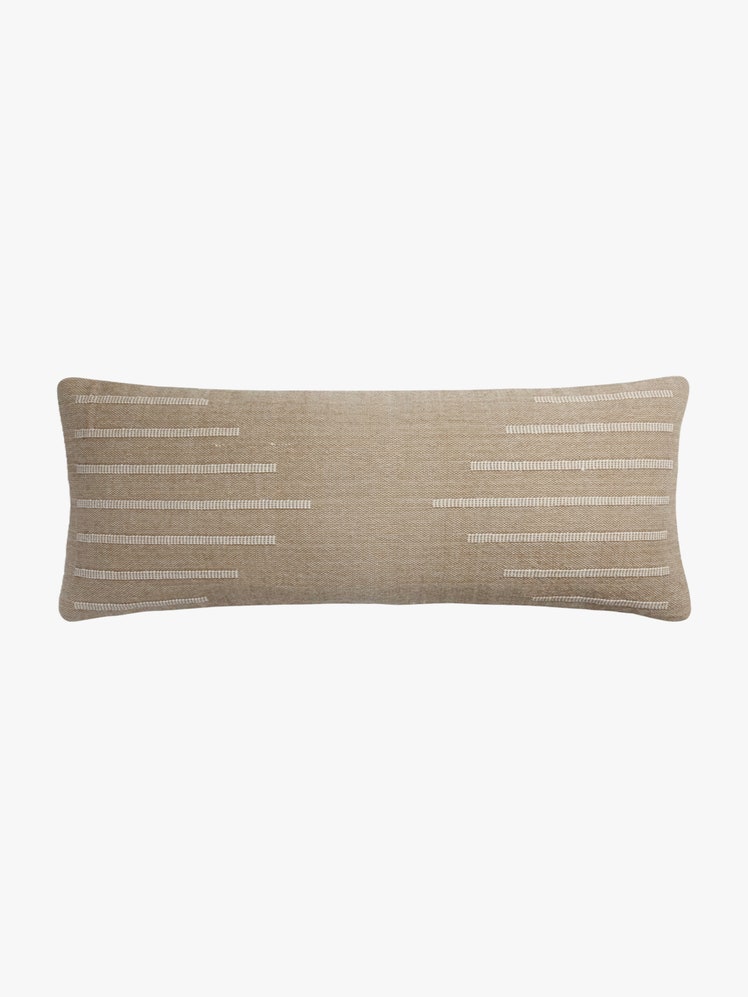 Brown lumbar pillow with beige lines of stitching to create a geometric pattern.