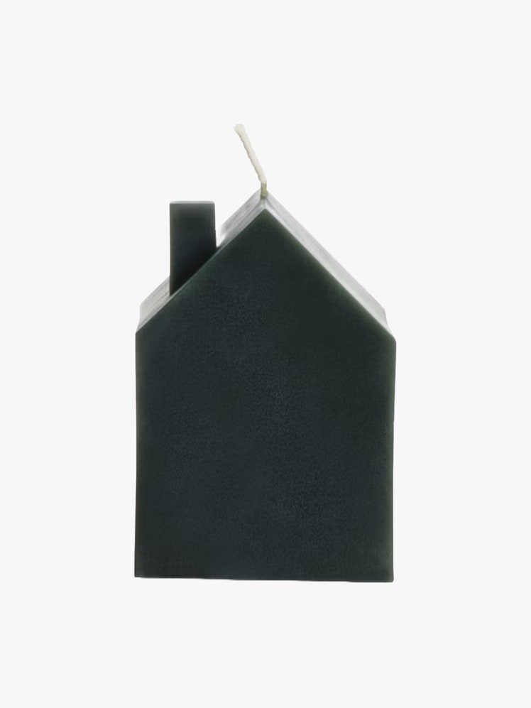 Green candle shaped like a house with a wick out of the top.