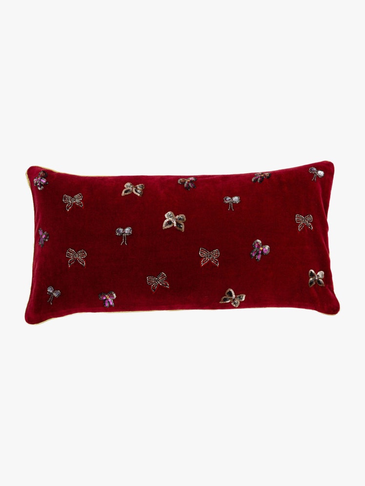 Lumbar pillow in red cotton velvet with hand embroidered beaded bows scattered on the front.