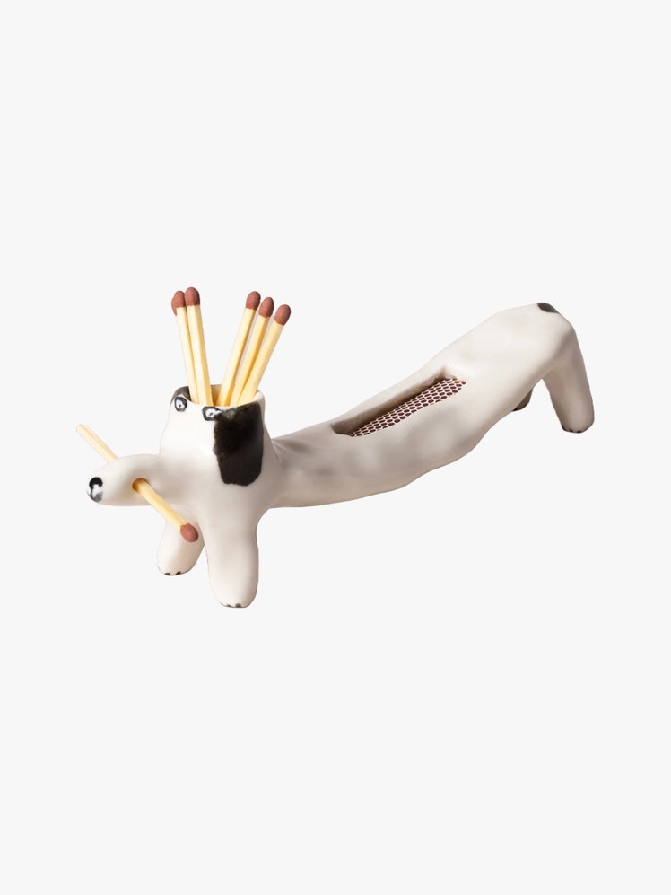 Ceramic holder for matchsticks shaped like a dog with a strike pad on its back.