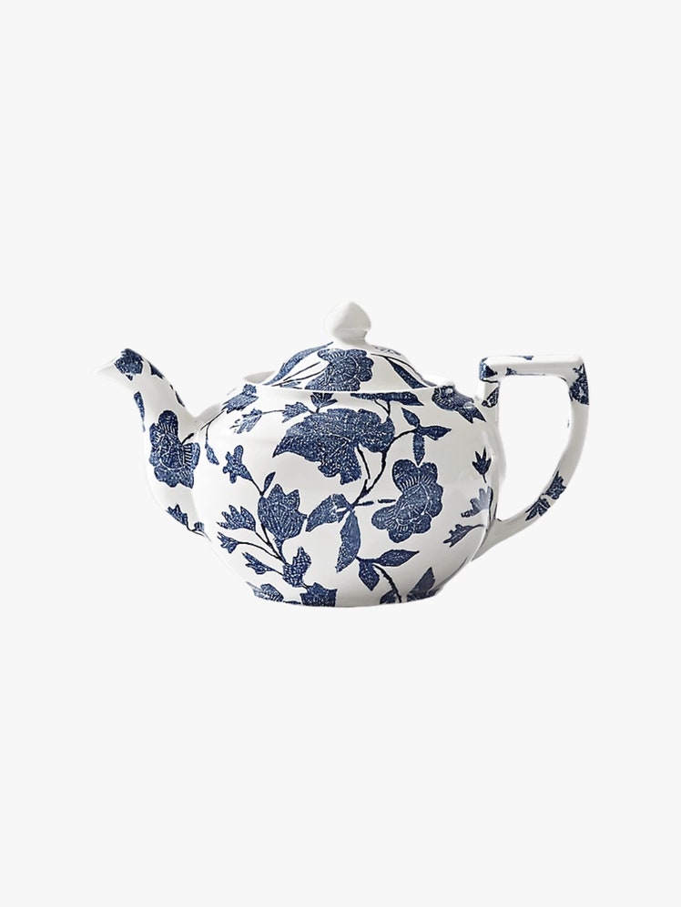 White ceramic teapot with a blue leaf print design.