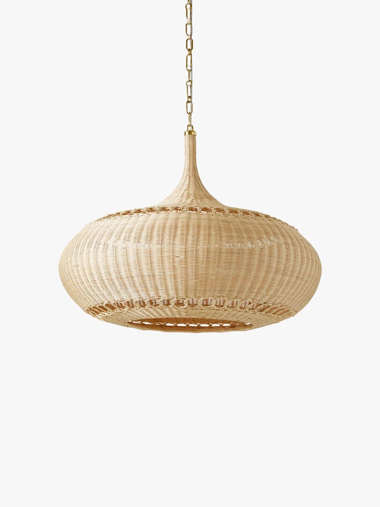 Spherical rattan pendant light hanging from a gold chain.